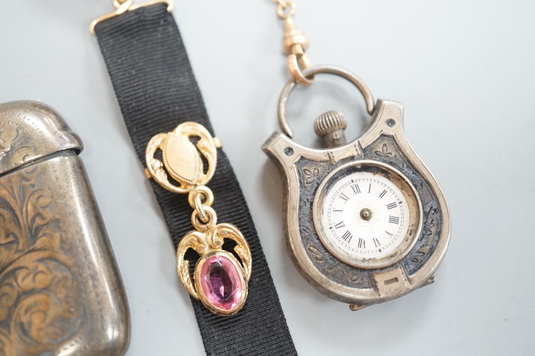 A silver vesta case, 48mm and a white metal cased fob watch, on a black sash suspension.
